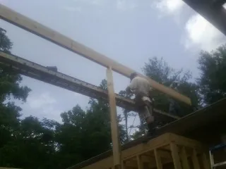 Carpenter setting a ridge beam over a new addition frame — Ice Dam Removal by Roofing Brothers in Berwick
